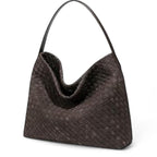 De trois quarts, le sac tressé brun montre son volume souple et son fond légèrement biseauté