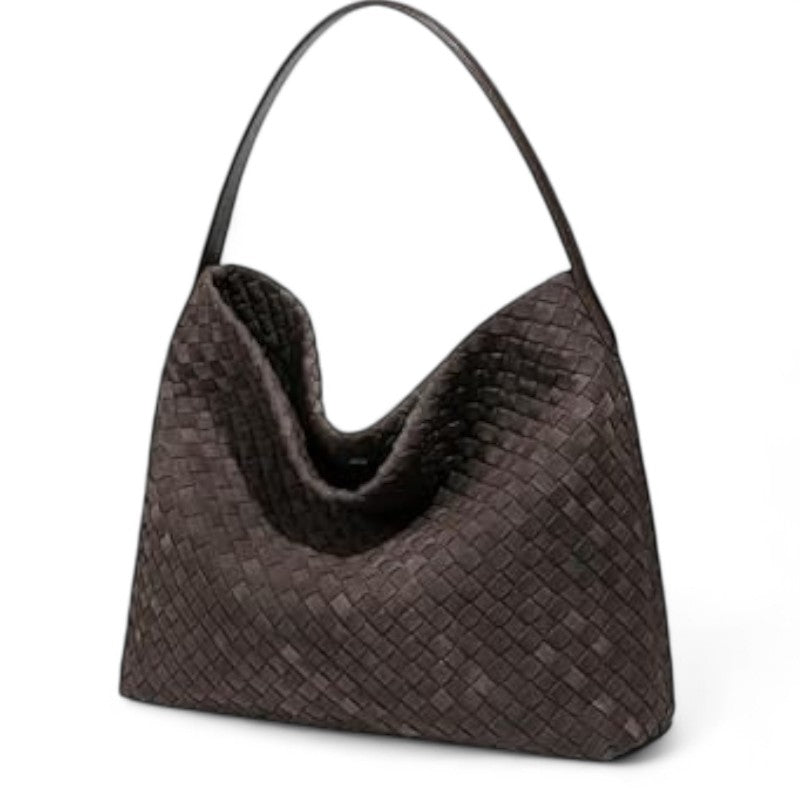 De trois quarts, le sac tressé brun montre son volume souple et son fond légèrement biseauté