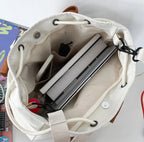Ordinateur portable glissé dans le sac ouvert, doublure claire et cordon de serrage écarté