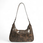 Dos lisse du sac croissant brun patiné, simple patte de cuir végan et anse fine réglable