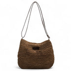 Sac seau en paille crochetée brun foncé, bandoulière fine réglable et petite étiquette cousue