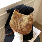 Tenu à la main devant un blazer noir, le sac en paille claire montre son maillage crocheté