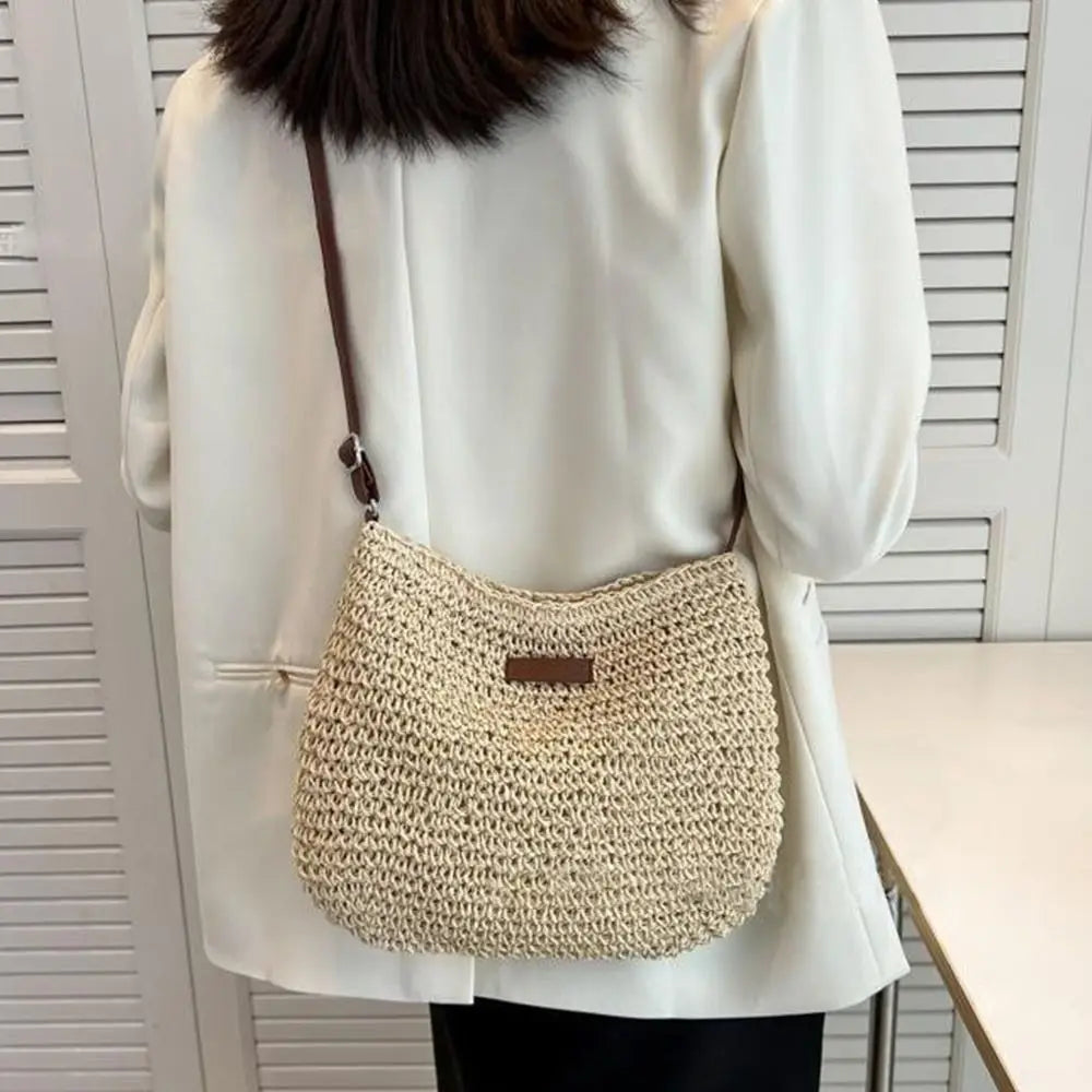 Porté en croisé dans le dos sur une chemise blanche, le sac en paille beige suit la hanche