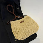 Paille naturelle crochetée à plat sur une veste sombre, lanière réglable à boucle repliée