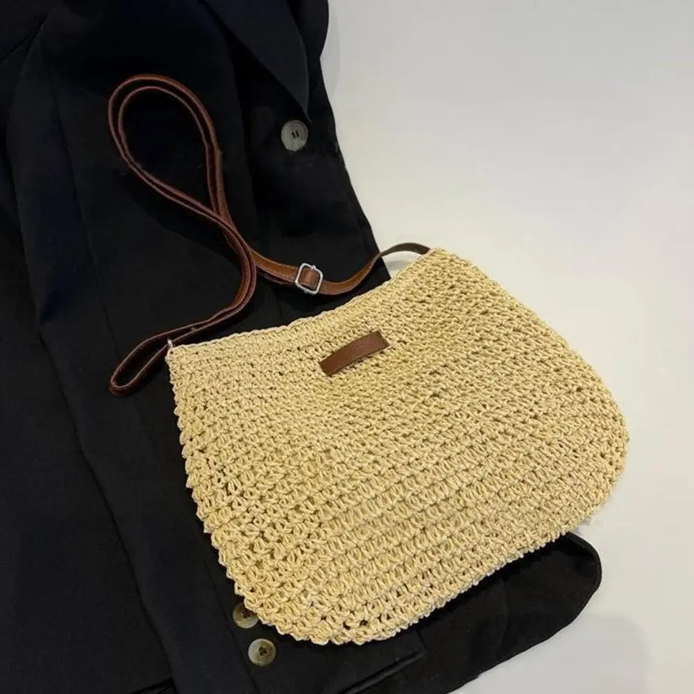 Paille naturelle crochetée à plat sur une veste sombre, lanière réglable à boucle repliée