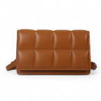 Format plat et rembourré en cuir végan cognac, damier de coussins et sangle amovible sur le côté