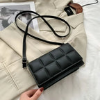 Rabat matelassé noir posé sur une veste beige, longue bandoulière déroulée en boucle à côté