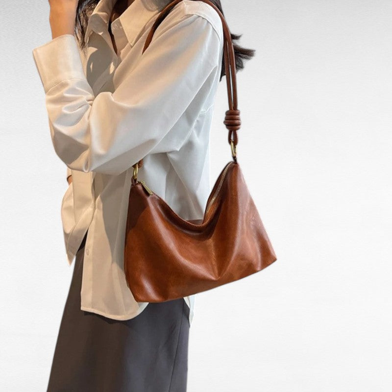 Épaulé sur une chemise écrue, le sac baguette marron châtaigne suit la ligne du buste