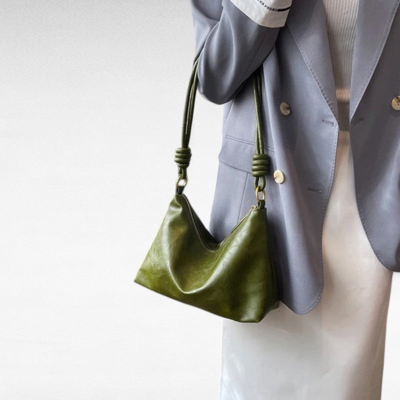 Sur un blazer gris perle, la baguette vert olive se porte sous le bras par son anse courte