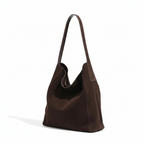 Trois quarts du sac chocolat en suédine, base large et anse renforcée par une patte cousue
