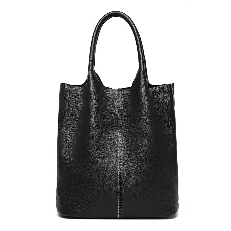 Tote vertical noir en cuir végan grainé, pris de face, anses rondes et surpiqûre centrale nette