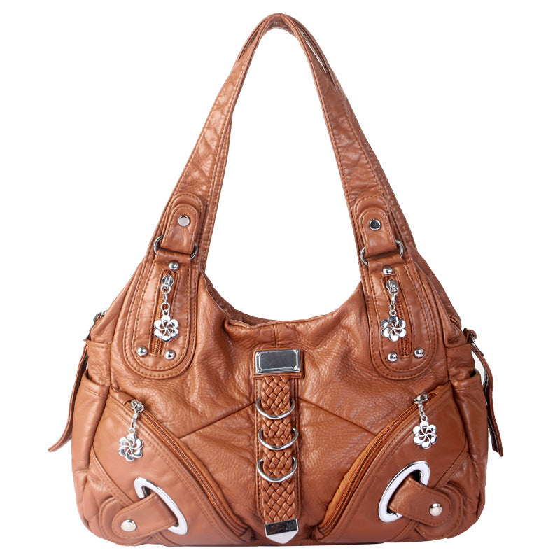 Roux cognac délavé, ce sac d'épaule affiche tresse verticale, œillets métalliques et breloques