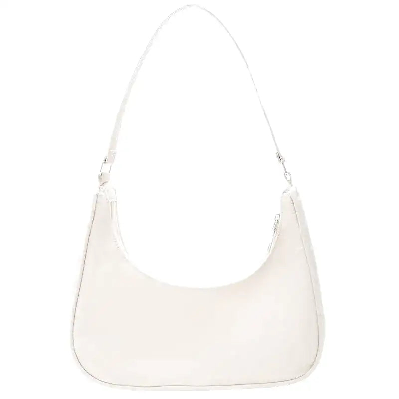 Blanc cassé et surface lisse, le même petit sac demi-lune se porte serré sous le bras