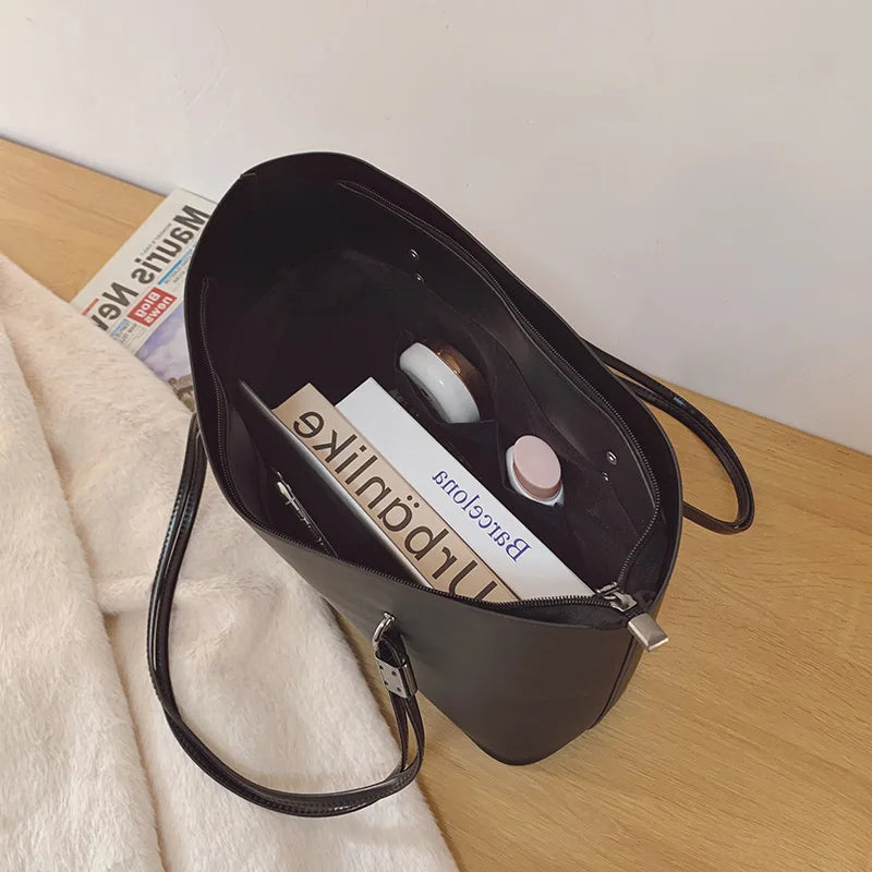 Vue plongeante dans le cabas sombre, un magazine glissé à plat contre la paroi souple