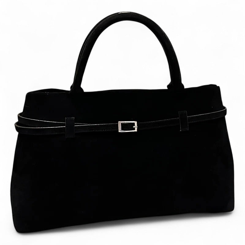 Noir profond sur une suédine mate, cabas à ceinture fine et boucle carrée, photographié de face
