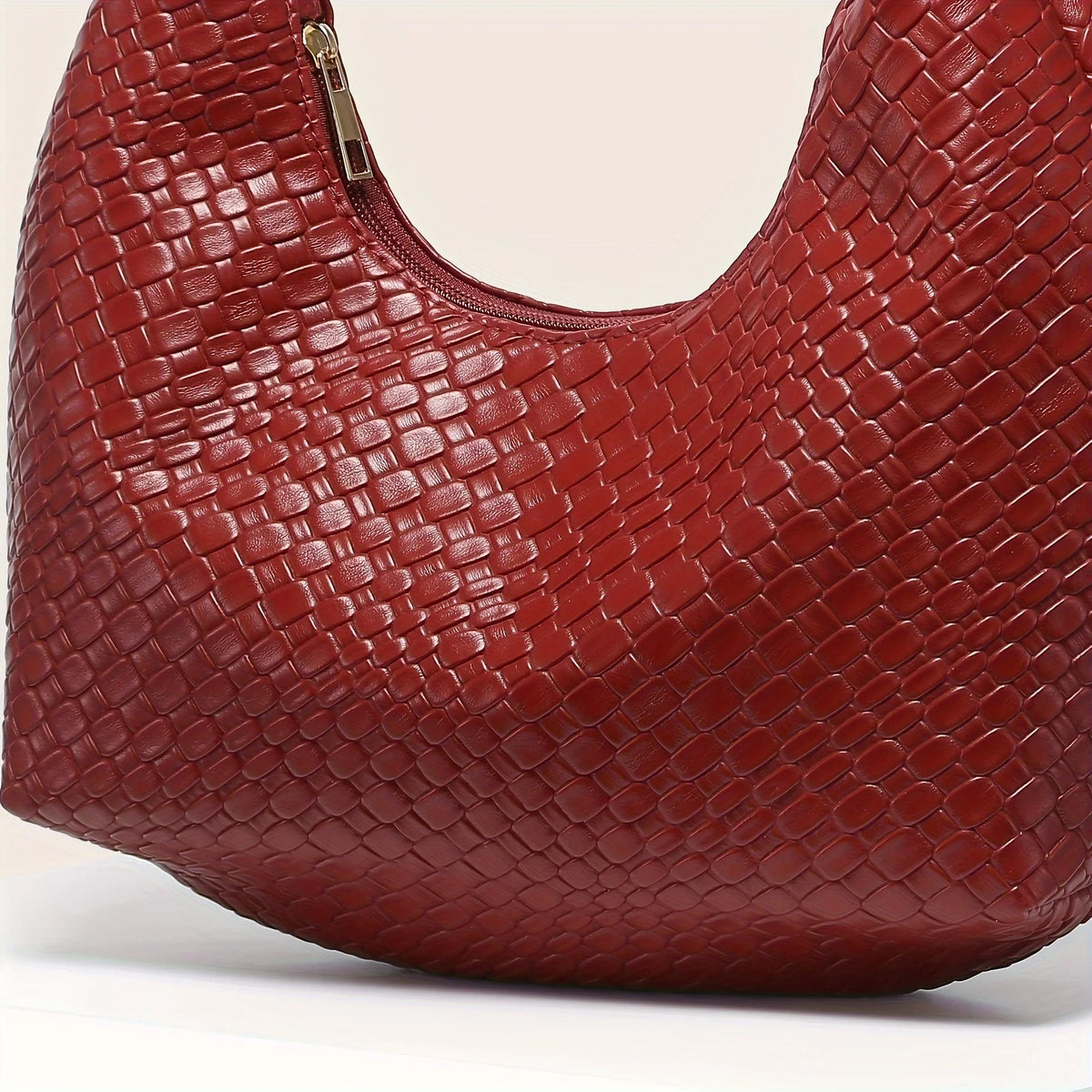 Macro du tressage en cuir végan rouge brique, reliefs entrecroisés et brillance douce du grain