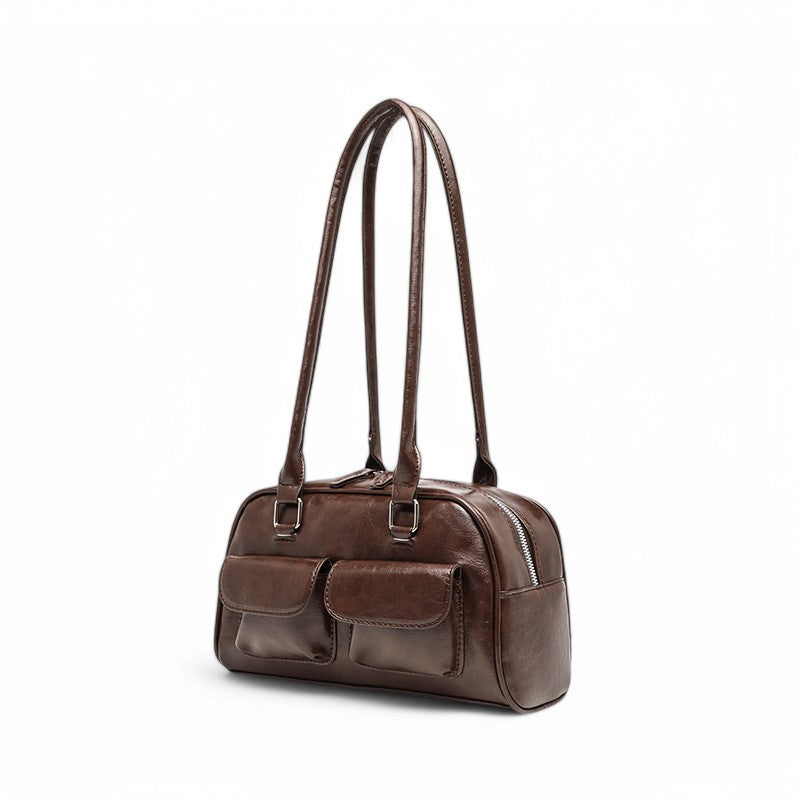 Profil de trois quarts du sac café, soufflet zippé et poches à rabat bien visibles