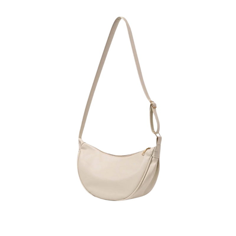 Écru crème et lisse, ce sac croissant se porte en longue bandoulière, zip courbe sur le dessus