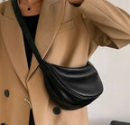 Buste vêtu d'un manteau camel, sac noir demi-lune porté en travers sur la poitrine