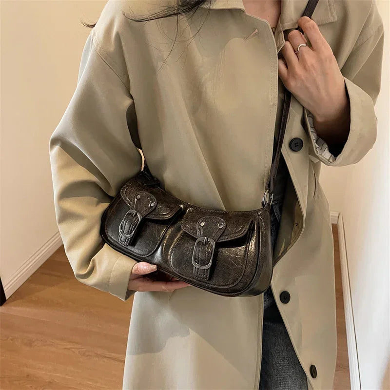 En croisé sur un trench beige, le sac baguette brun foncé se cale au creux de la taille