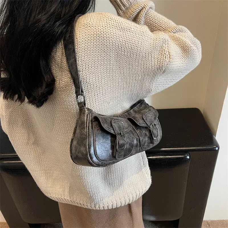 Sur un pull écru, la version noire délavée se porte en croisé et repose bas sur la hanche