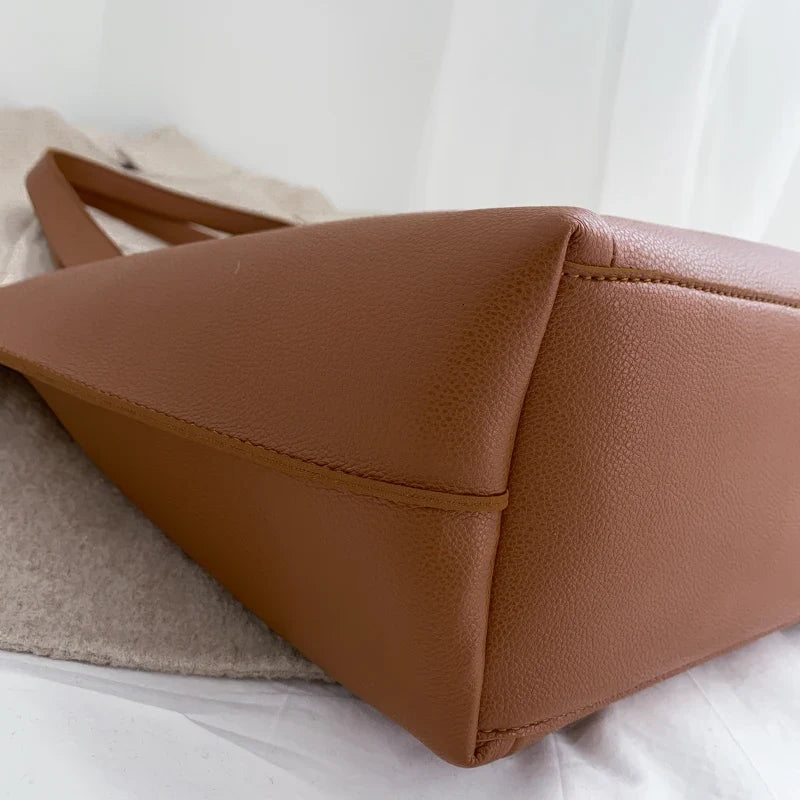 Dessous et coin du cabas marron, base large et coutures d'angle du cuir végan grainé