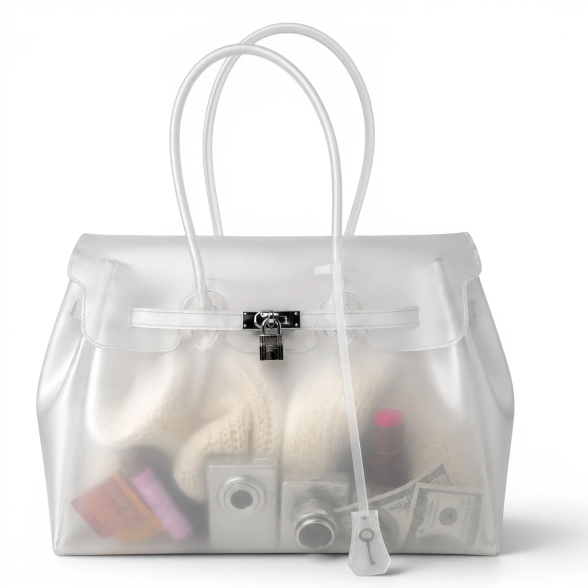 Version givrée incolore du sac en PVC, vue de face, on distingue un tricot et de petits objets