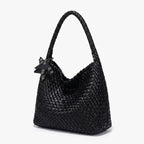 Tressage serré du sac noir vu de trois quarts, base élargie et anse d'épaule arrondie