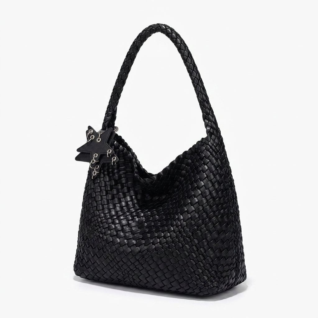 Tressage serré du sac noir vu de trois quarts, base élargie et anse d'épaule arrondie