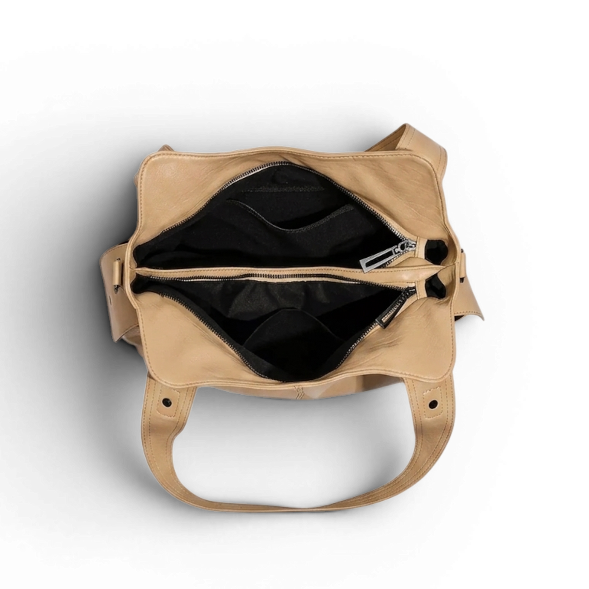 Intérieur doublé de noir, poche zippée centrale et large ouverture du sac beige vus de dessus