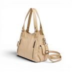 De profil trois quarts, le sac beige laisse pendre sa longue bandoulière détachable