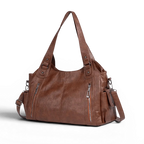 Décalé de trois quarts, le sac marron laisse voir sa poche latérale et sa sangle réglable