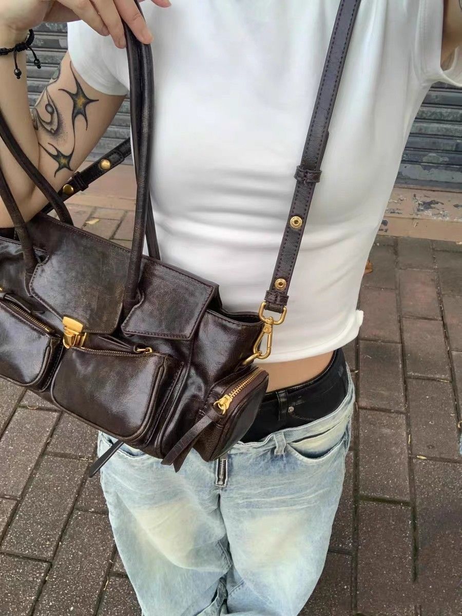 Bandoulière réglable portée en croisé dans le dos, sac brun patiné sur un jean clair et un top