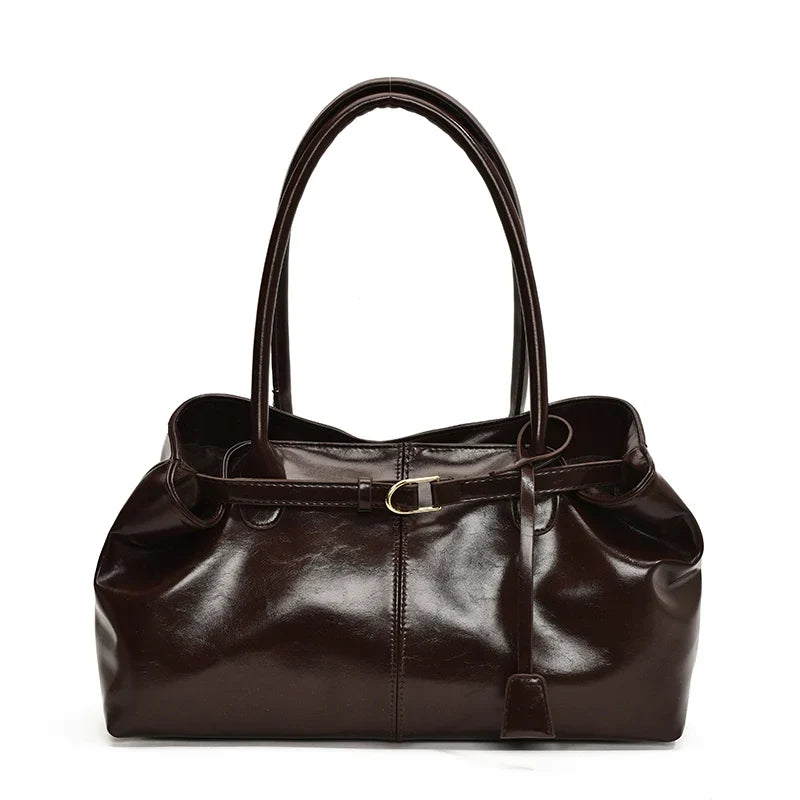Brun café presque noir, le sac baguette se présente de face, anses fines et bandeau ceinturé